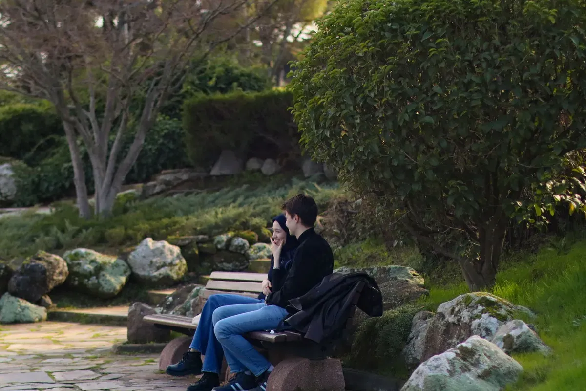 公園のベンチで少し間を置いて座る二人